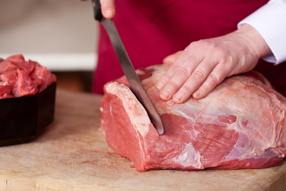 Butcher cutting meat.